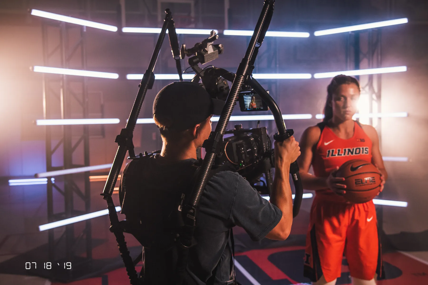 A basketball player lit by tube lights on a studio set