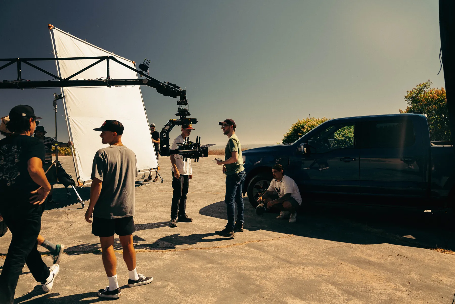 Crew preparing a crane shot beside a truck